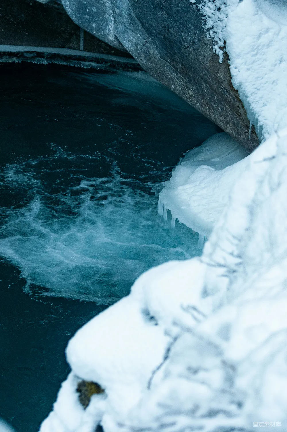 一条水流穿过覆盖着白雪的森林