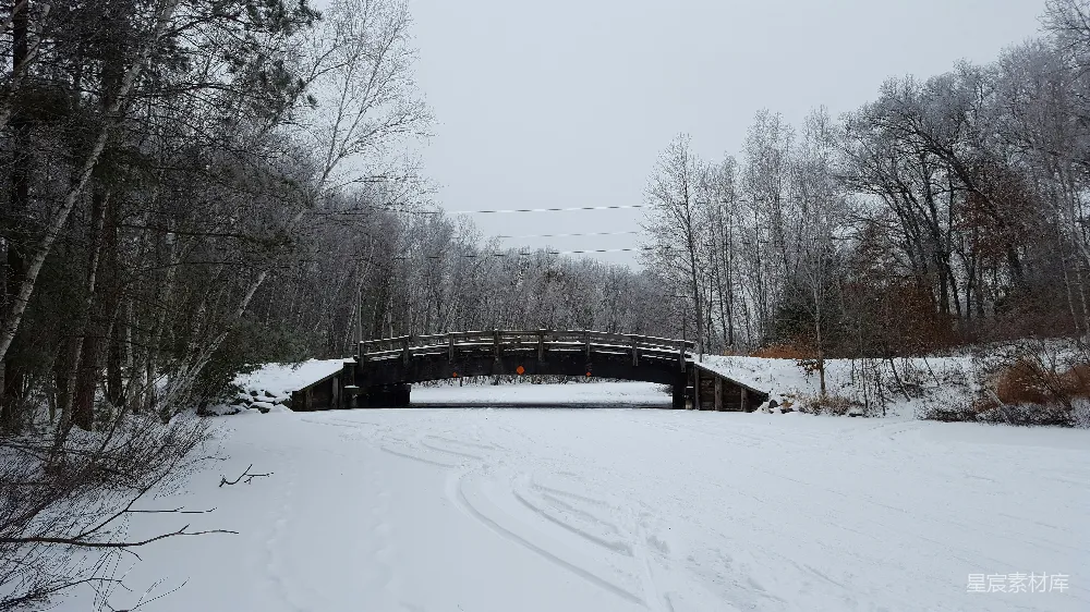 覆盖着白雪的道路以及一座桥横跨其上