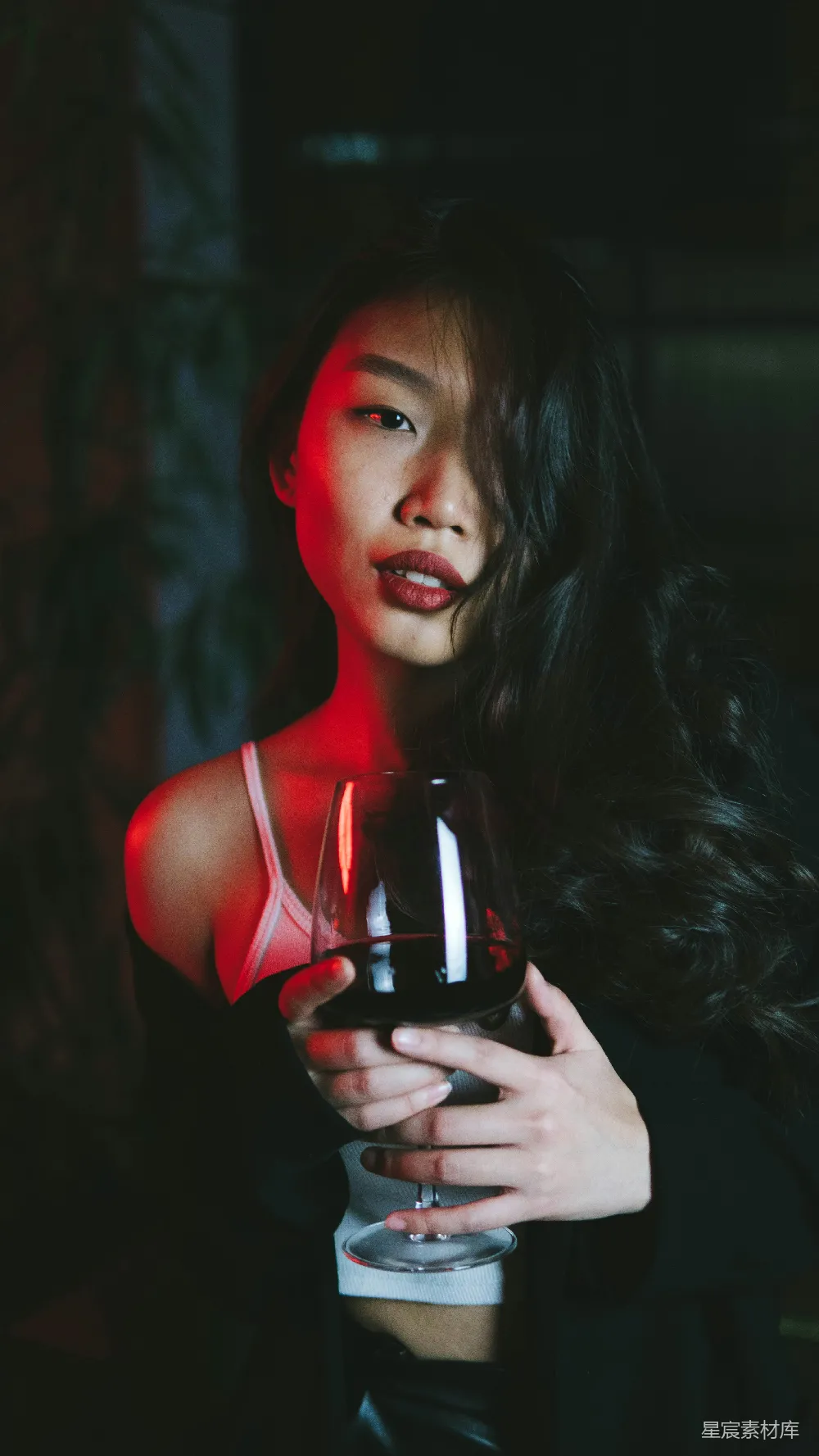 红色上衣女手持酒杯