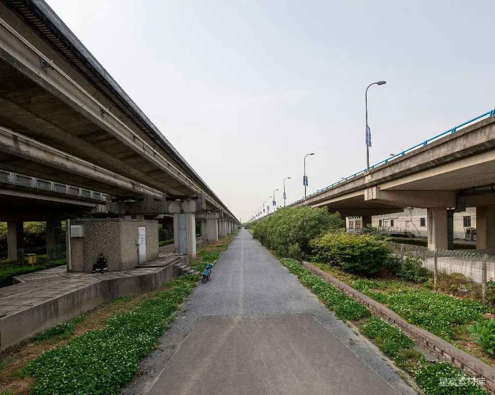 高清摄影  在高架桥下和绿树丛中的漫长道路