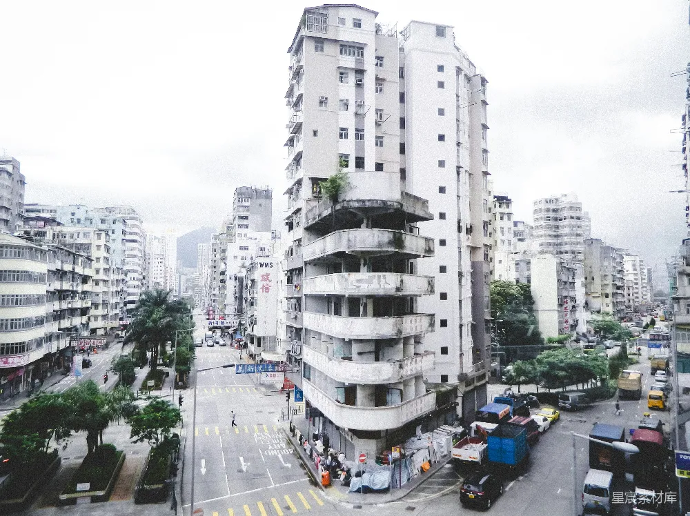 路旁高-rise建筑附近白天的车辆行驶场景