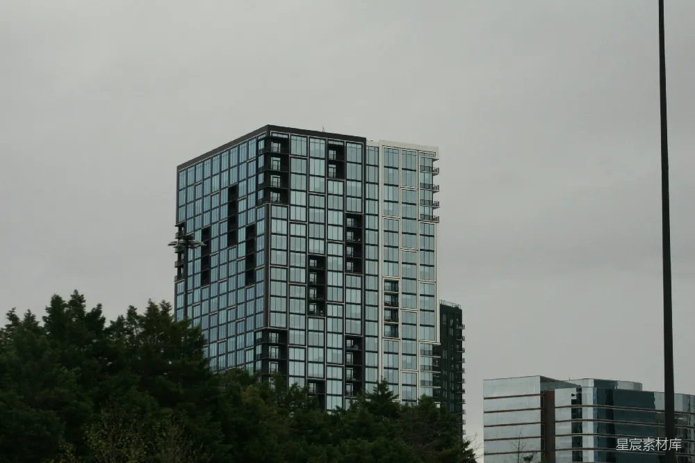 现代玻璃建筑矗立在阴云密布的天空下