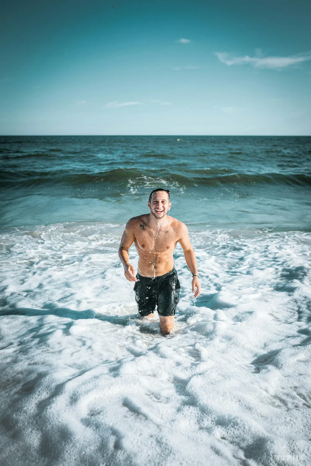 黑色短裤的男人站在海水中白天