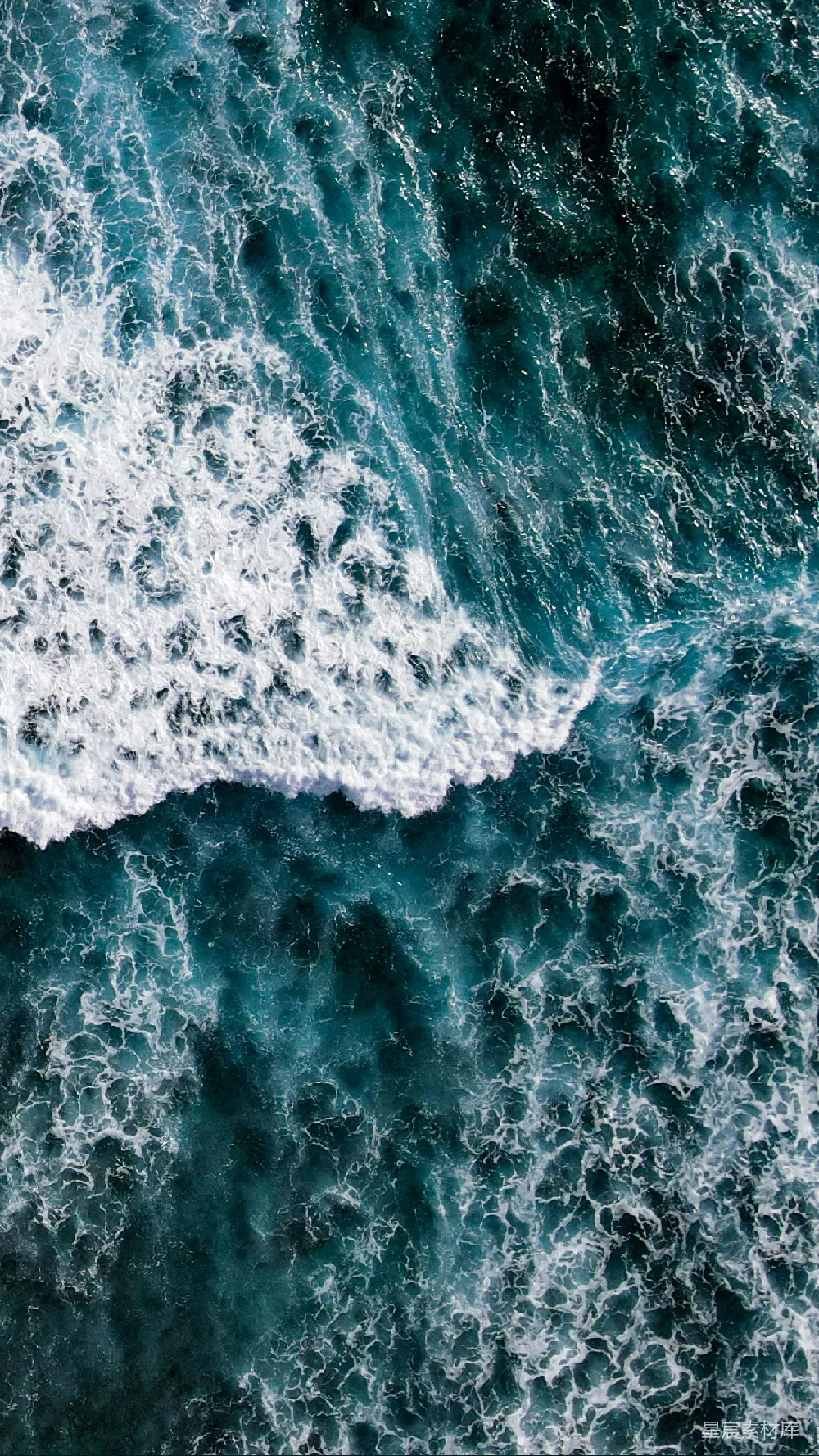海边一个骑着冲浪板的人在波浪上