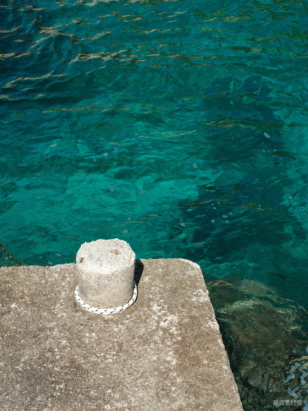 高清摄影  混凝土墩柱旁边是清澈的蓝绿色海水。
