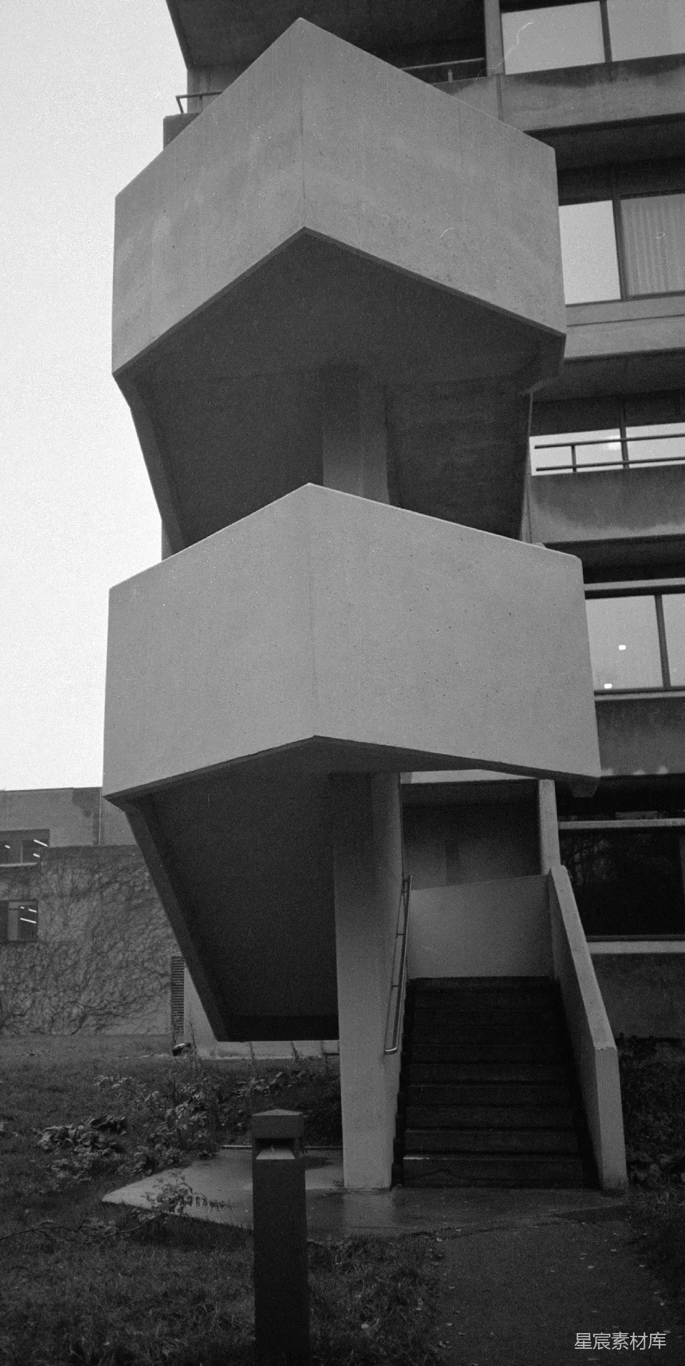 高清摄影  黑白相间的 Brutalist 建筑，外有几何形状的混凝土楼梯。