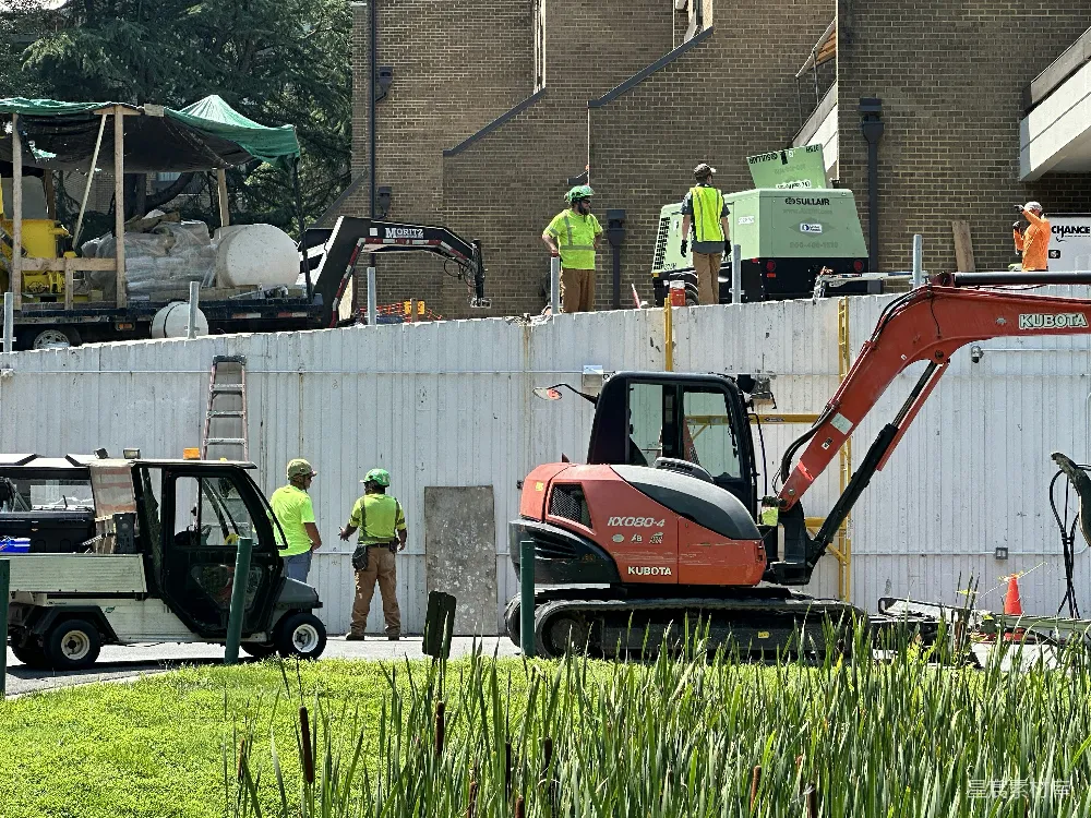 高清摄影  一群男人站在一个建筑工地周围。