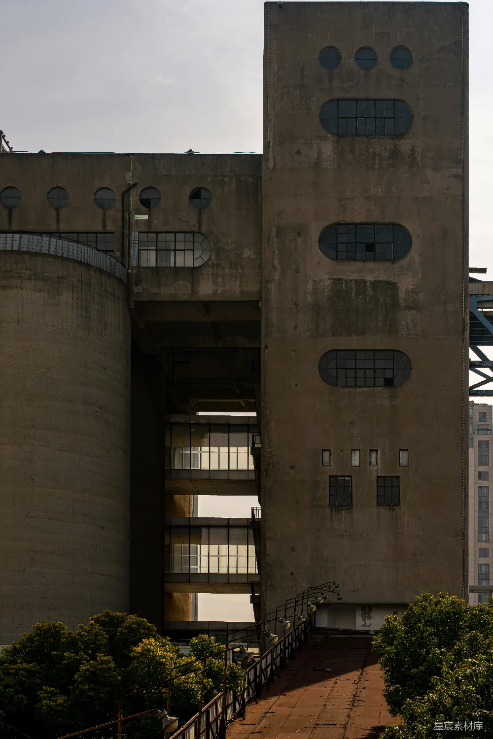 高清摄影  混凝土工业建筑，带有椭圆形窗户和圆形开口。