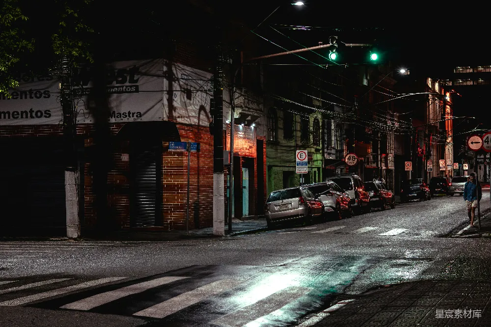 夜晚街道场景中有停放的车辆和交通灯。