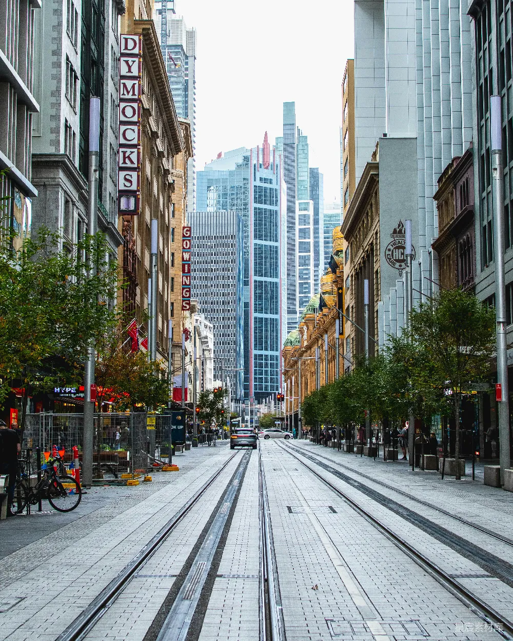 高清摄影  城市街道上有车辆行驶，路边停着汽车，这是白天的景象。