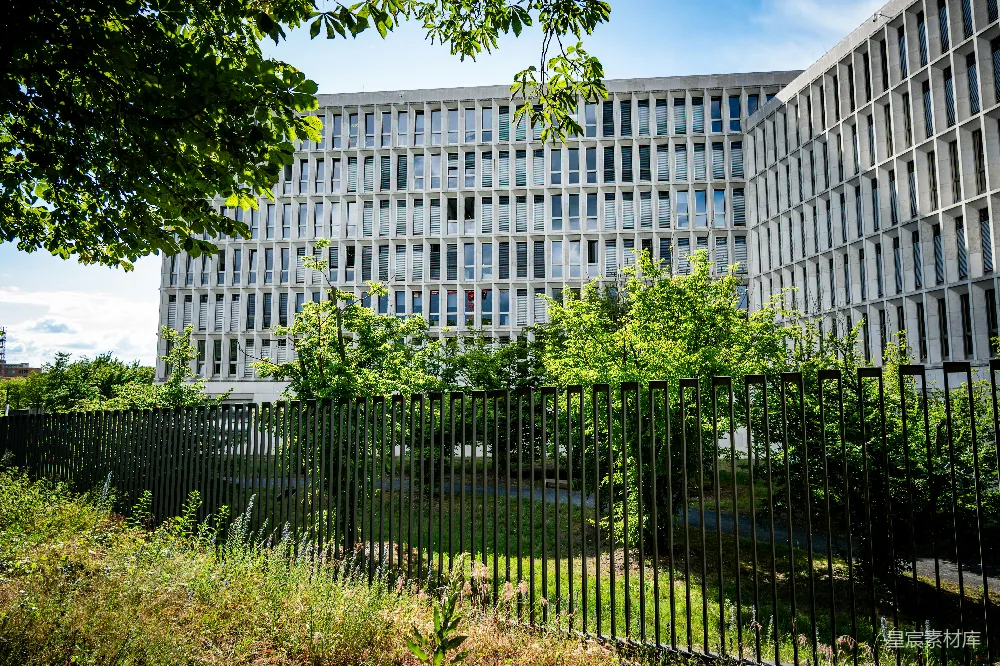 高清摄影  一座大型现代化建筑，窗户众多，被一排黑色栅栏隔开。
