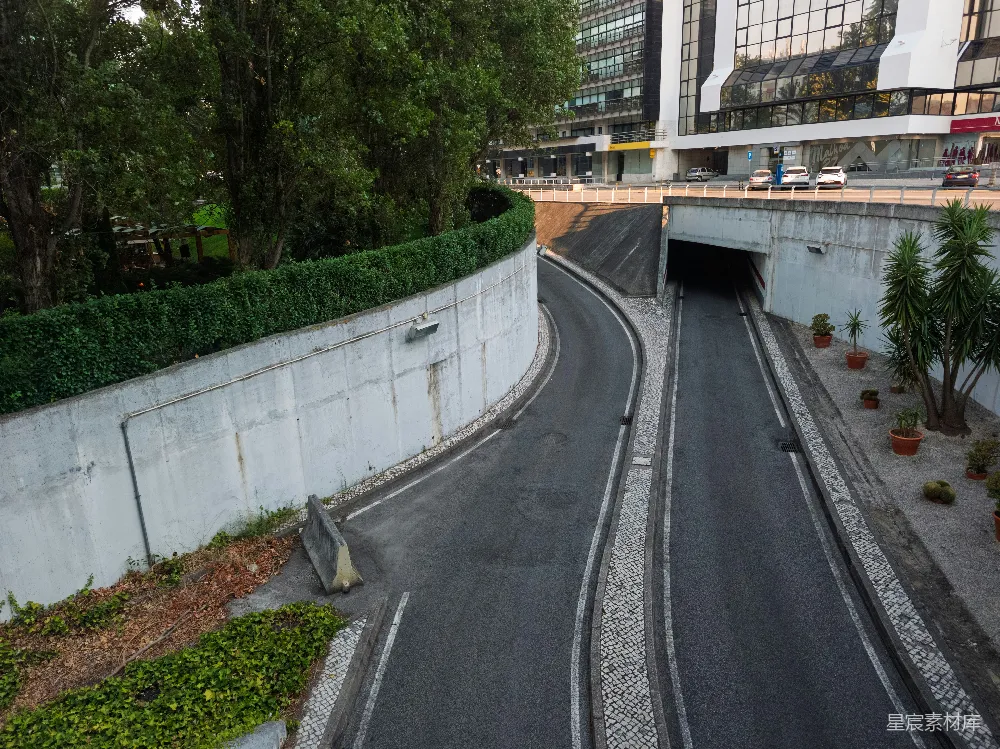 高清摄影  弯曲的道路逐渐延伸至黑暗的城市隧道中。