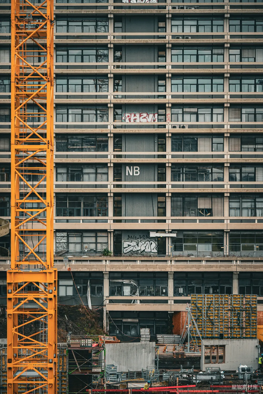 高清摄影  黄色的建筑起重机在混凝土建筑旁边