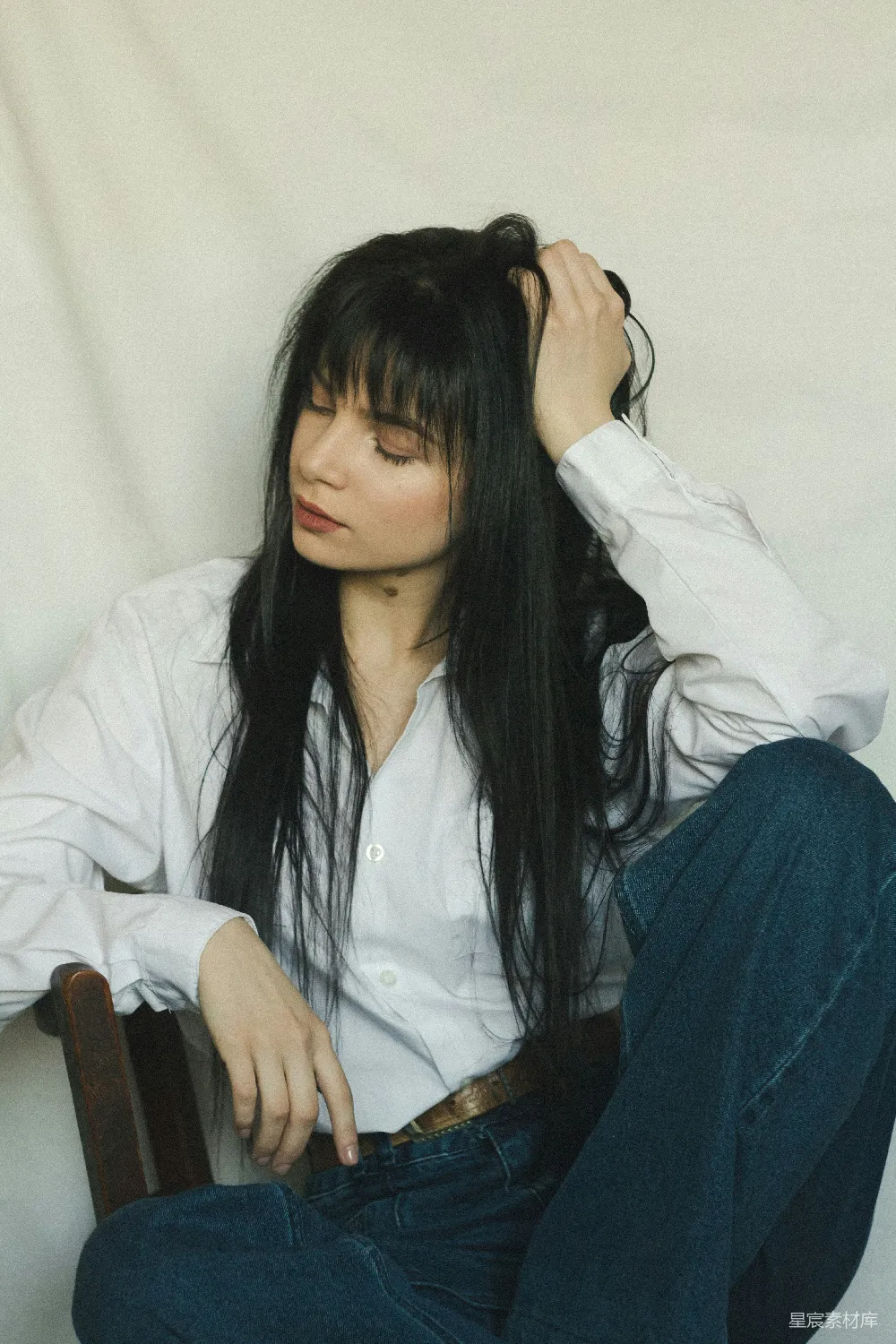 一头长发的妇女坐在椅子上。