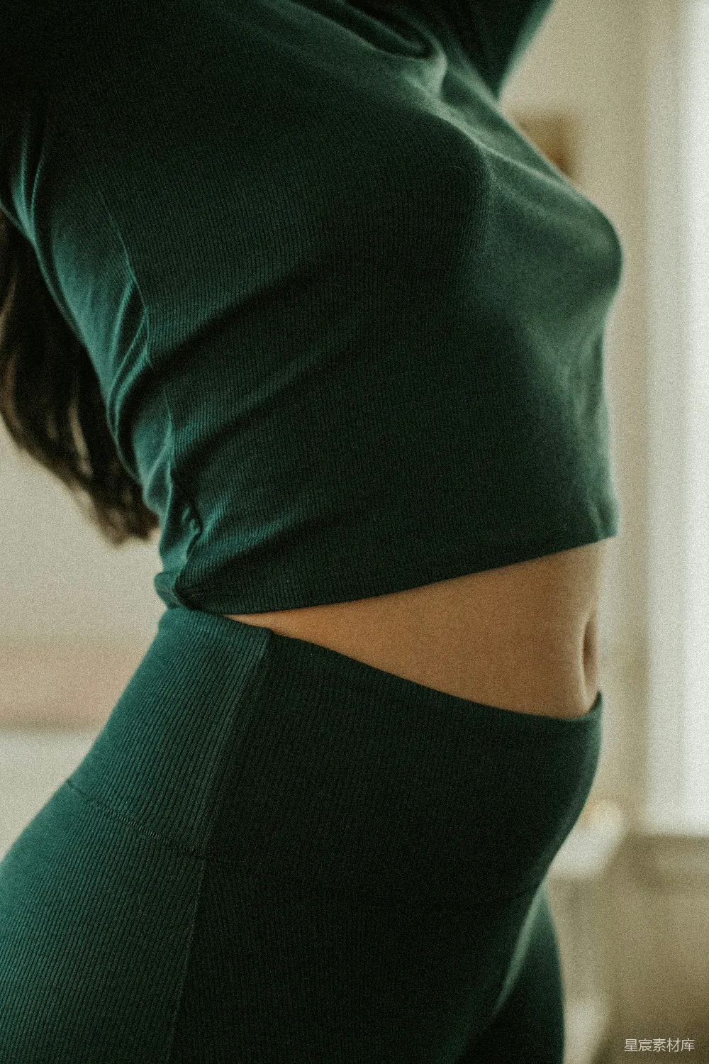 一个女人穿着绿色上衣和紧身裤