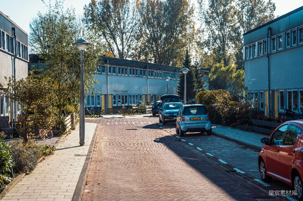 高清摄影  停在建筑物前面路边的汽车。