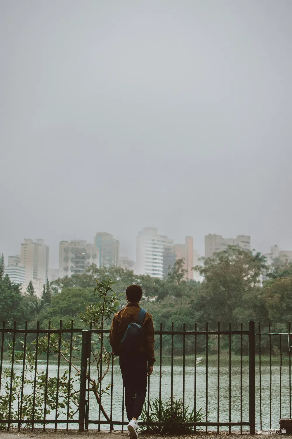 高清摄影  一个人站在桥上，望着城市。