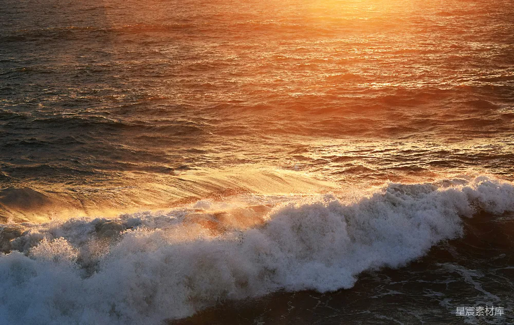 夕阳下海浪拍打海岸的景象
