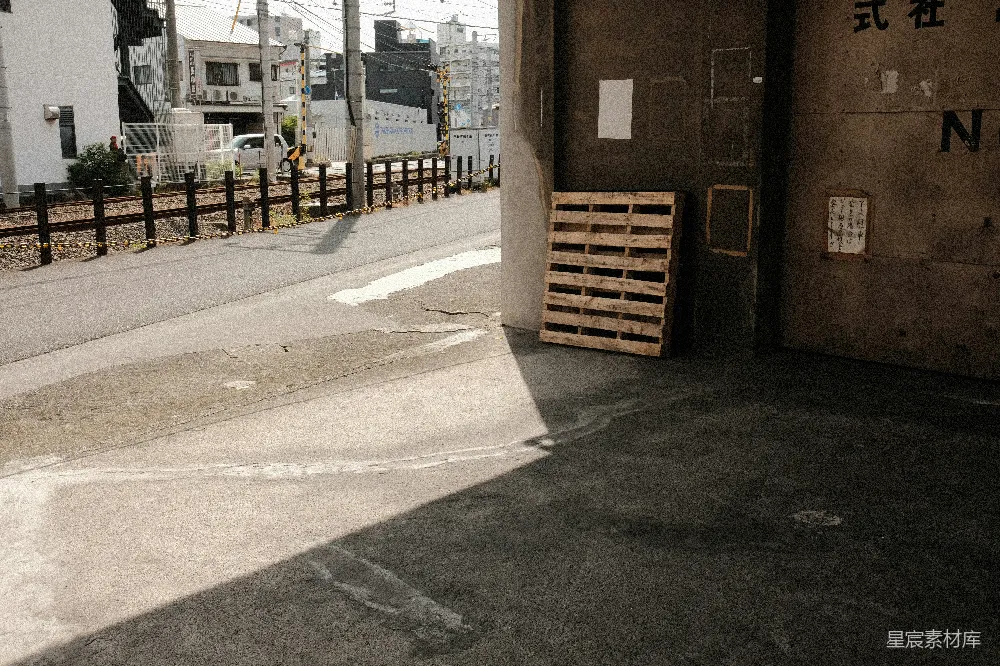 高清摄影  木制托盘靠近混凝土墙和街道。