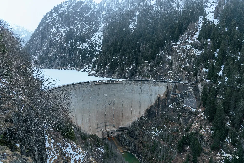 高清摄影  一座巨大的水坝矗立在雪山中央。