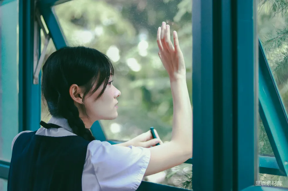 穿着学校制服的女士正向外看窗外。