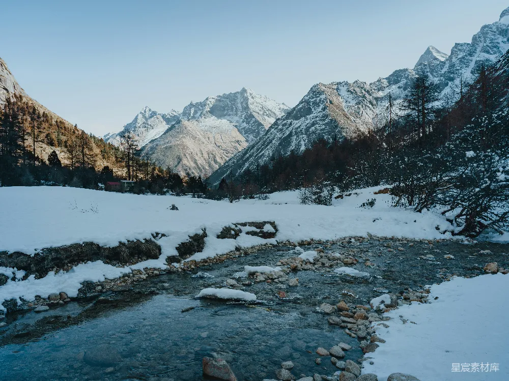 一条河流穿过一片雪覆盖的山谷