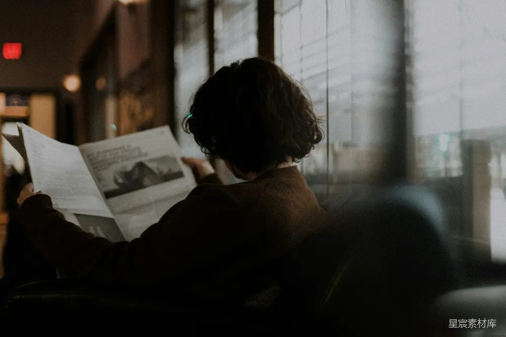 高清摄影  穿着棕色长袖衬衫的女人坐在窗边。