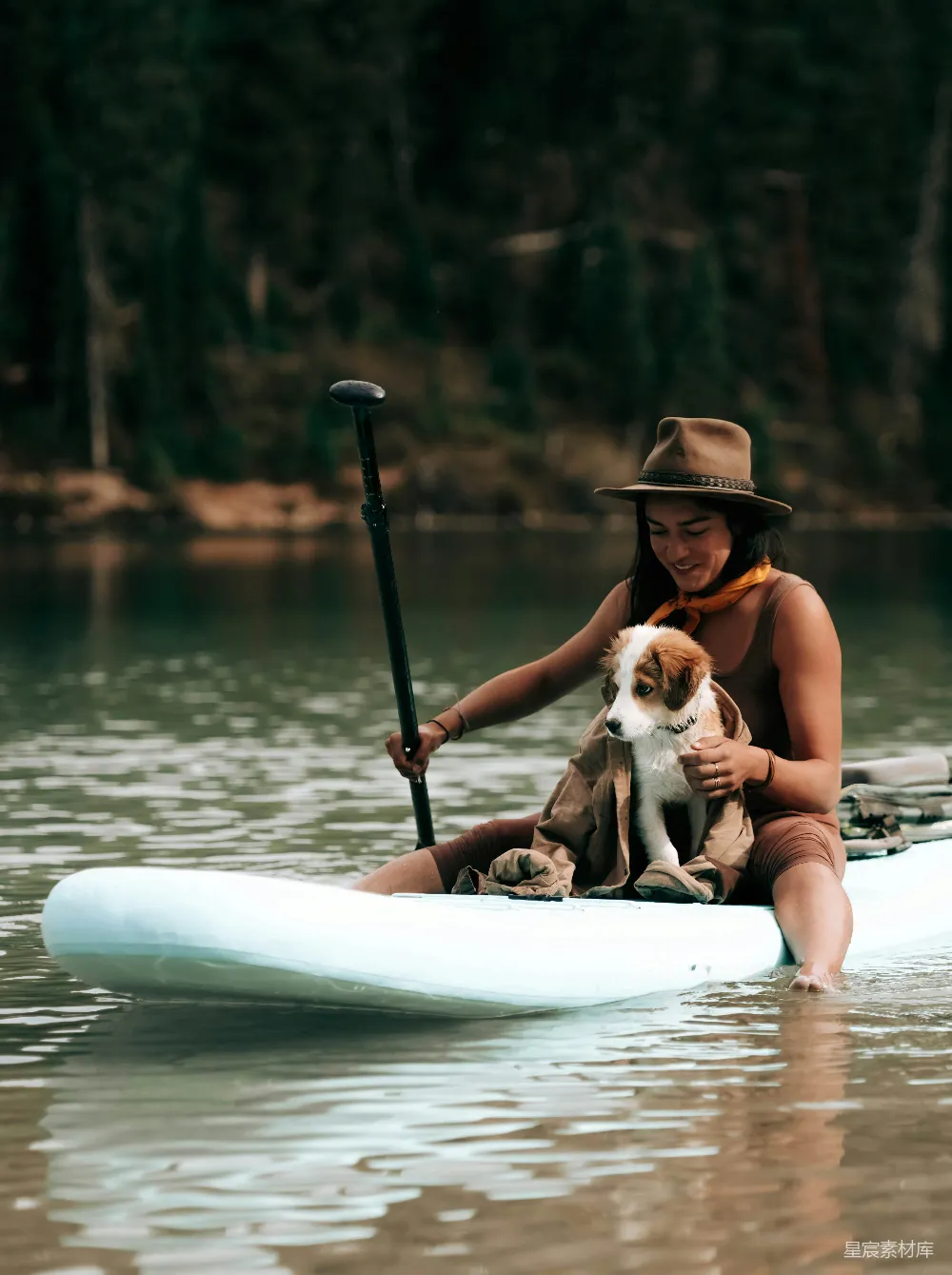 一个女人和她的狗在 kayak 中。