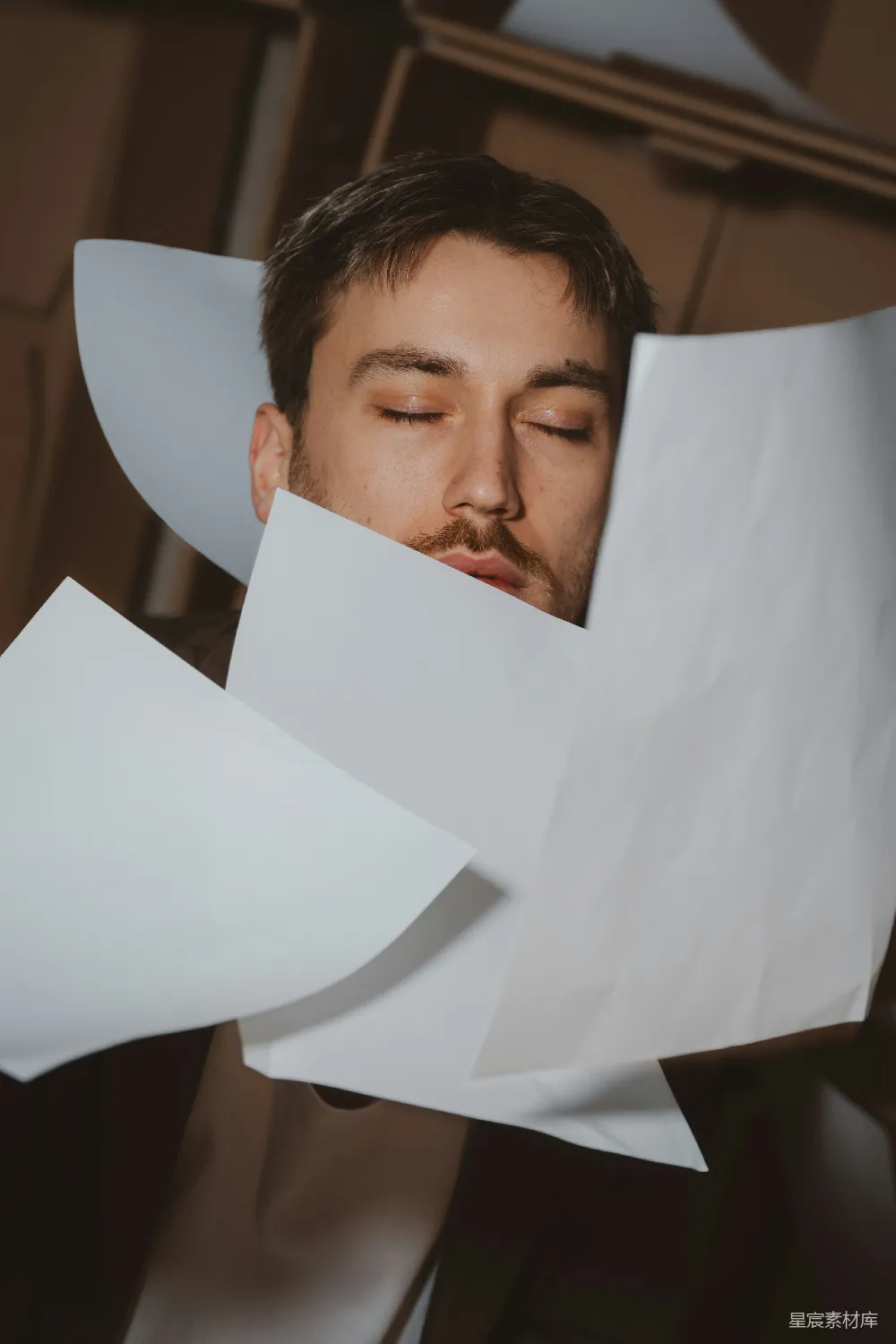 高清摄影  闭着眼睛的男人被飞舞的纸片包围着。