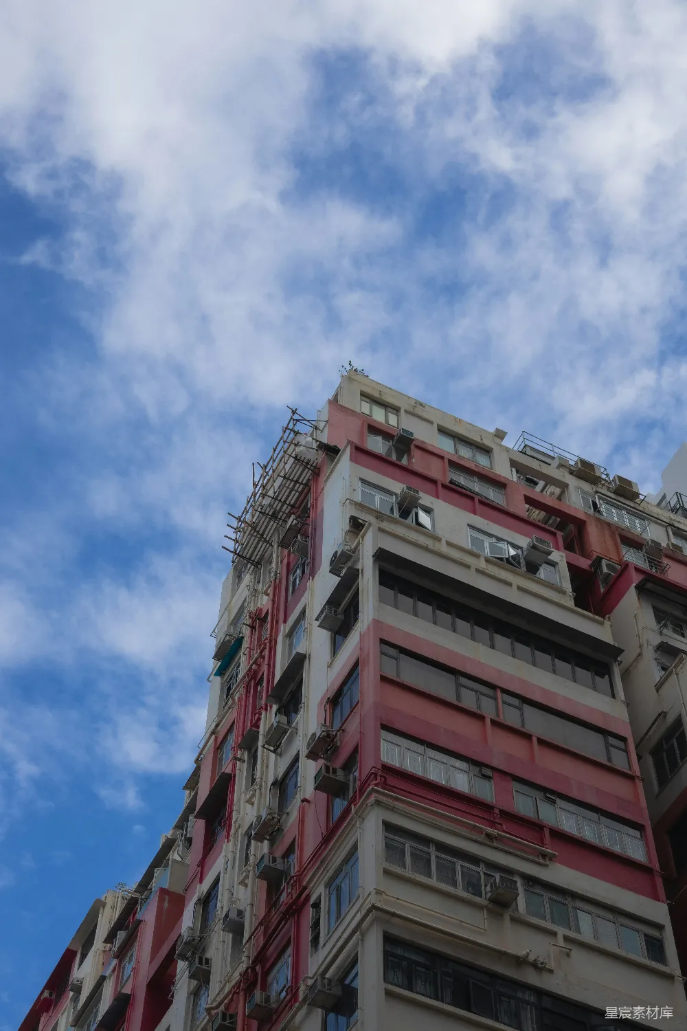 高耸的带有粉色和白色外墙建筑矗立在蔚蓝的天空中