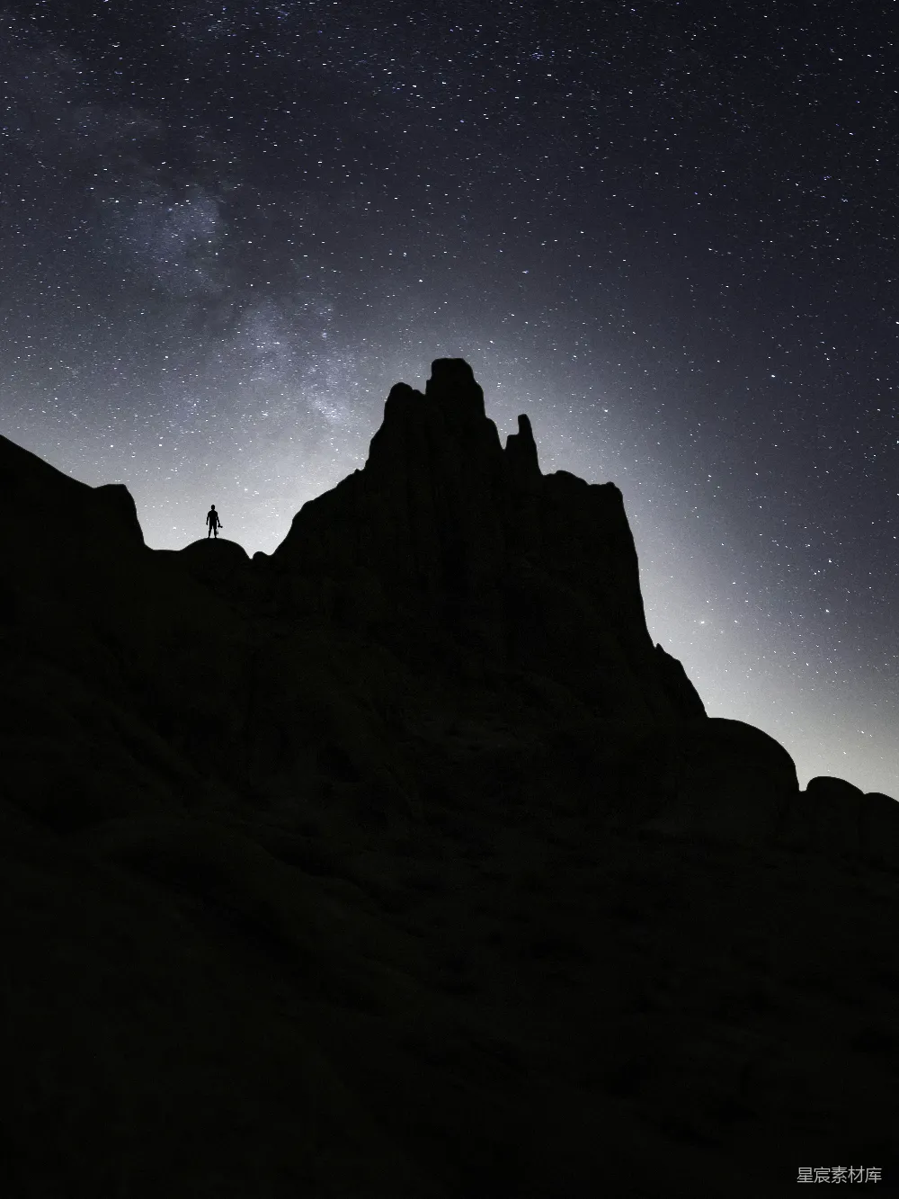 星下的岩石坡上一个人的轮廓。