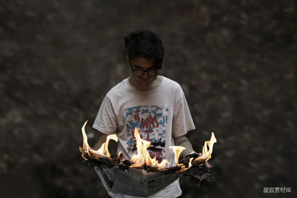 一个男子手握着一托火焰