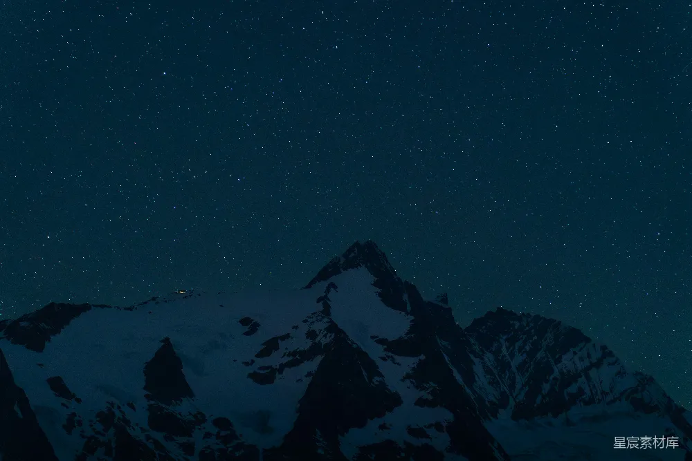 雪花覆盖的山峰在夜空中的繁星之下