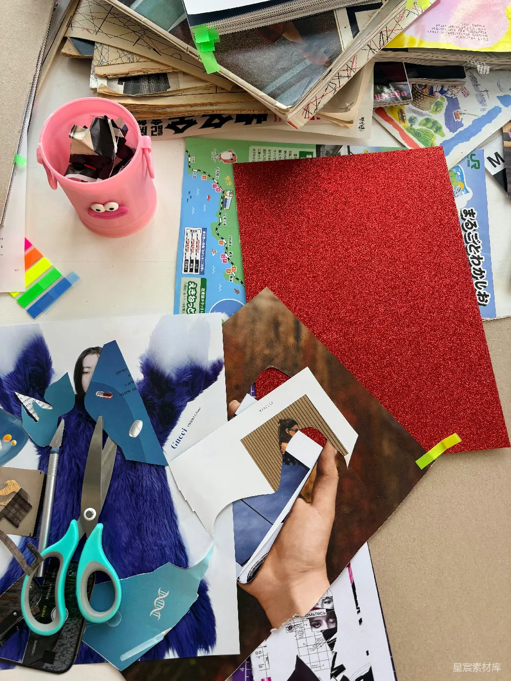 高清摄影  凌乱的办公桌上摆放着剪刀、制作材料和用于拼贴画的纸张。