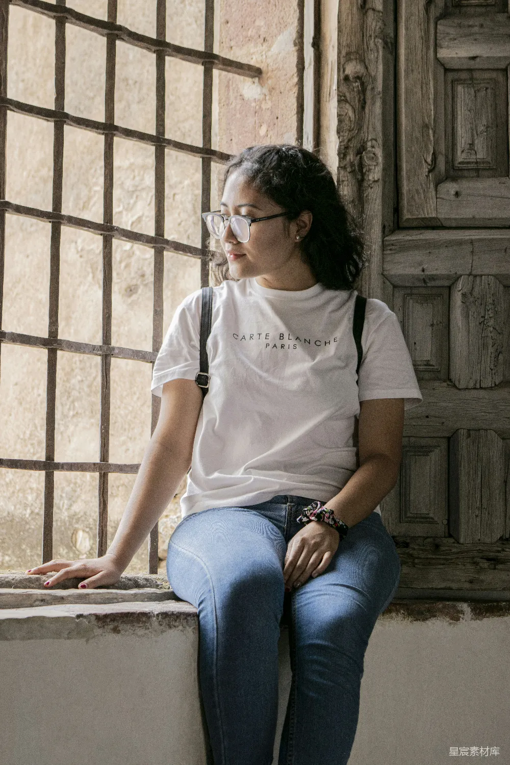 一个女人坐在窗台上向外看。