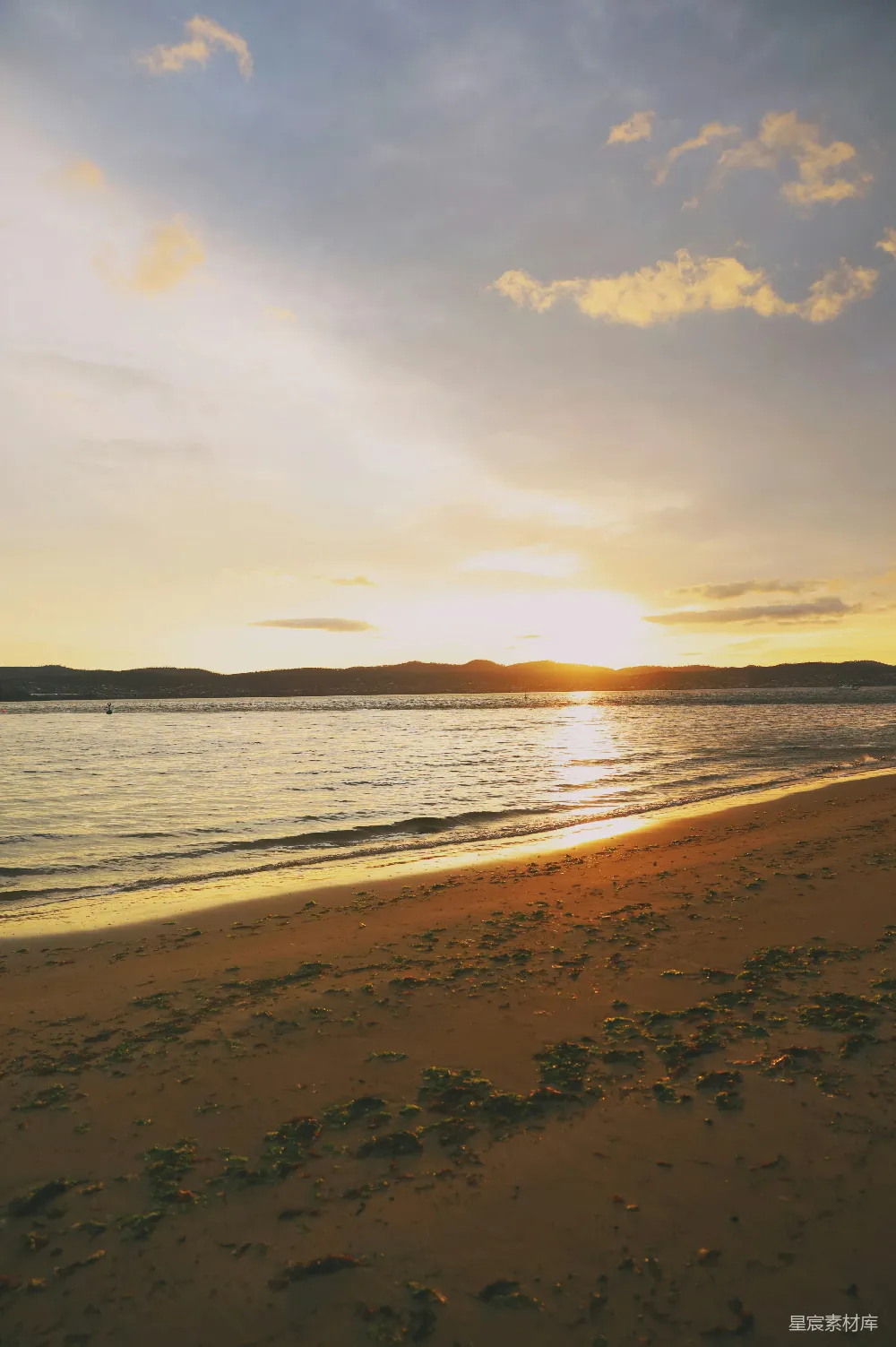 海滩上的太阳正缓缓沉入水中