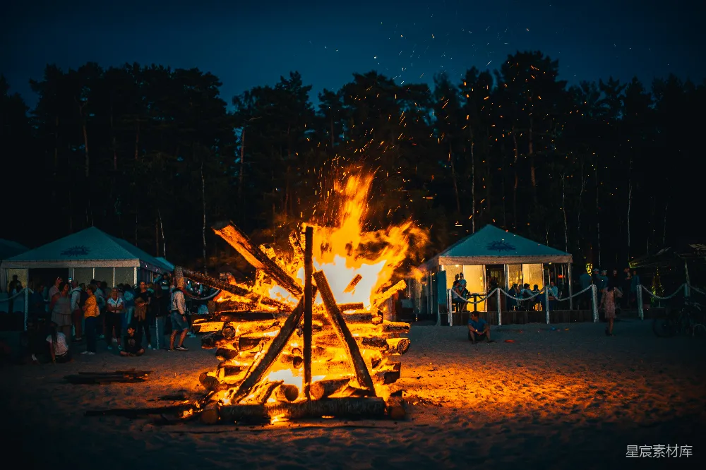 夜晚白桦木房屋附近燃起篝火