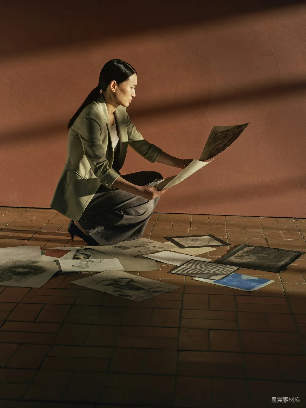高清摄影 人物 女人正在审视铺在地上的艺术品。