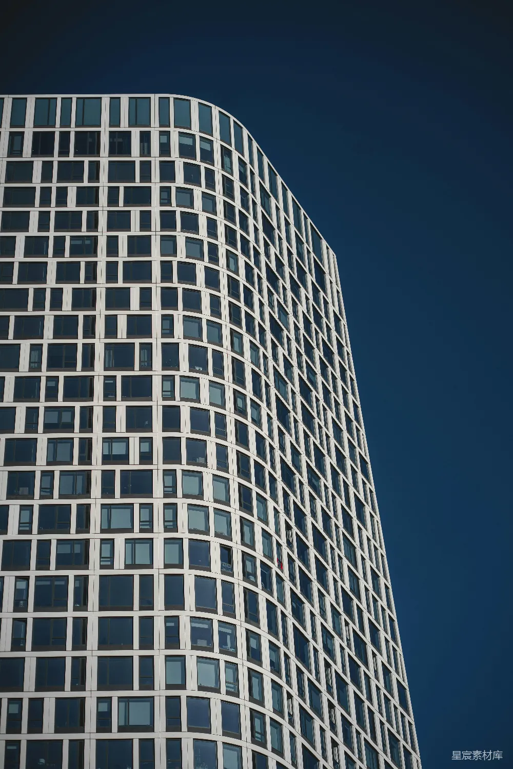 现代摩天大楼几何外观的建筑矗立在蔚蓝天空之下。