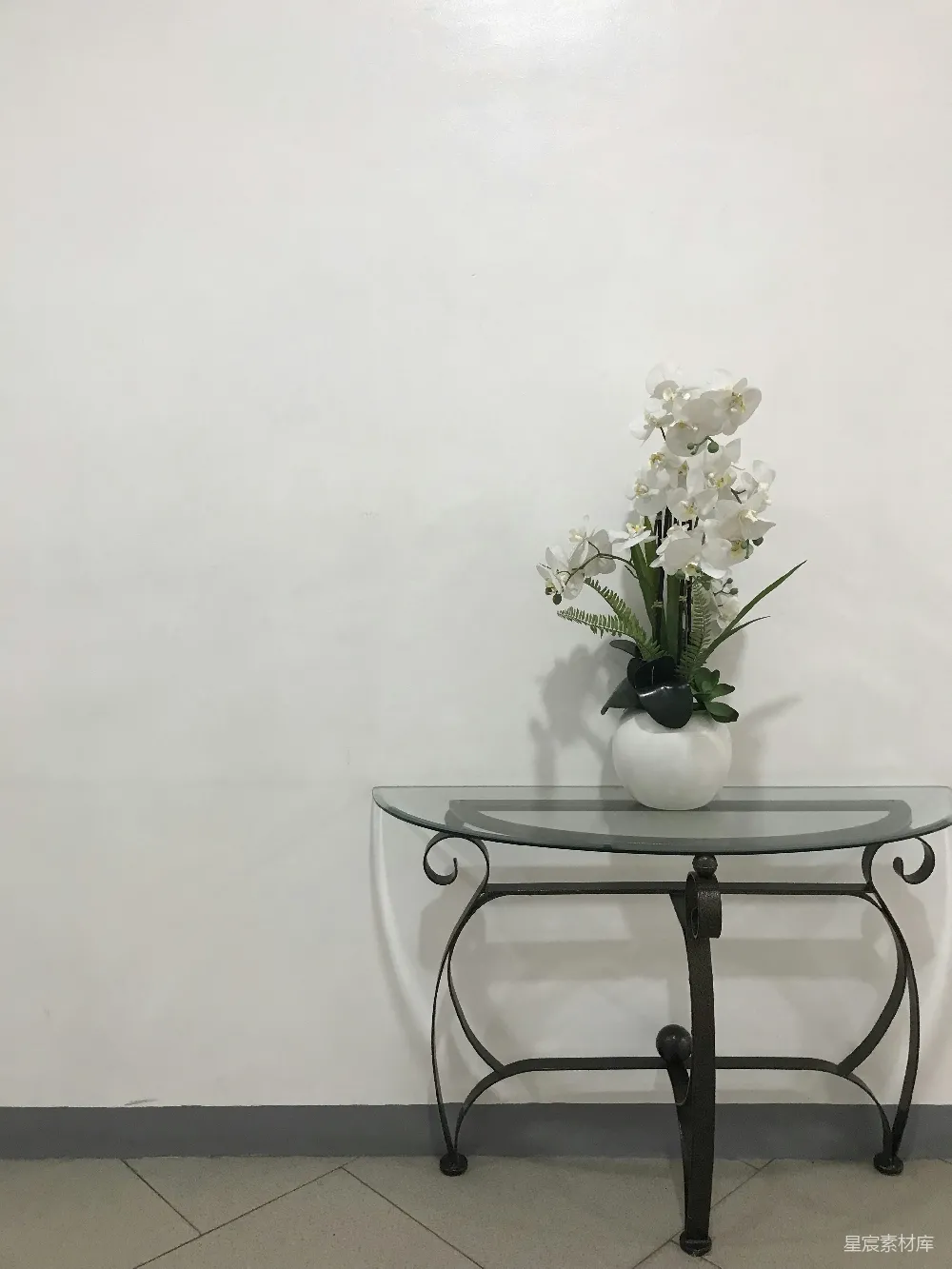 高清摄影  一张玻璃桌子，上面放着一束花的花瓶。