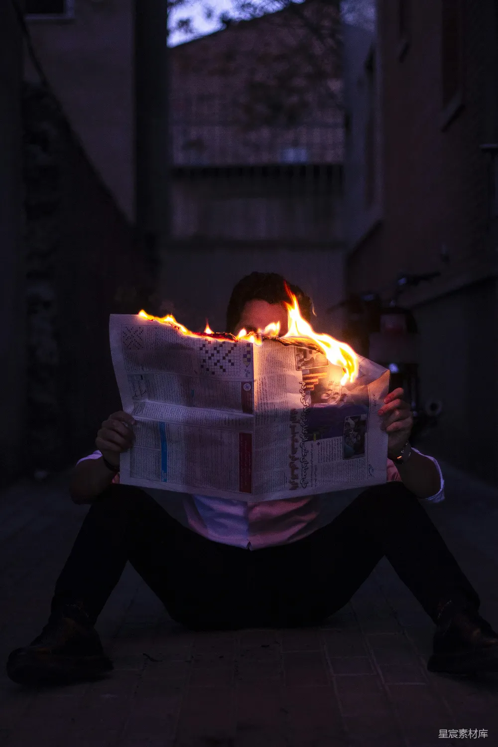 高清摄影  一个人坐在地上看报纸。