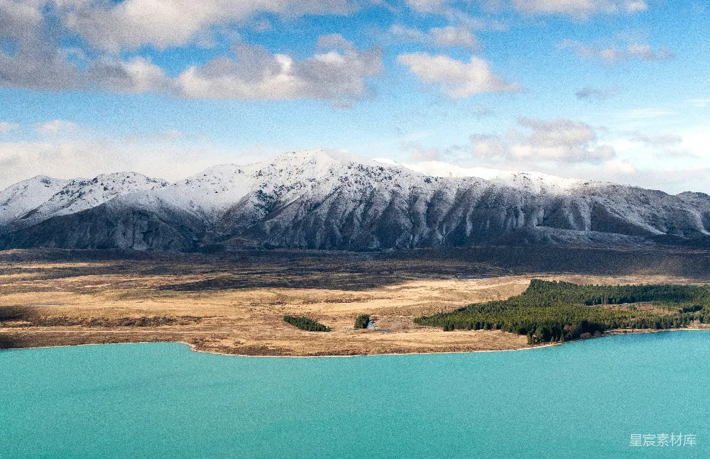 前景中有一片湖泊，远处是一组山峦的景象。