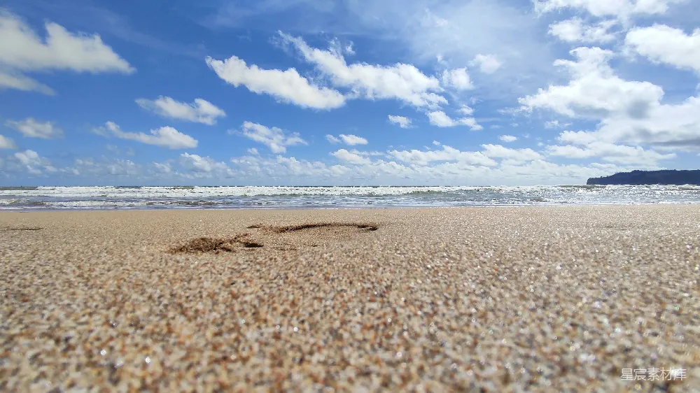 一片沙滩，海浪涌向岸边。