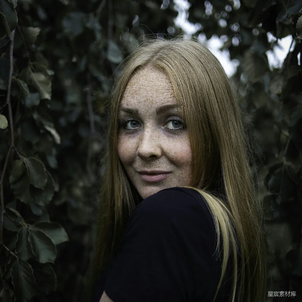 黑T恤的女人站在绿色植物旁边
