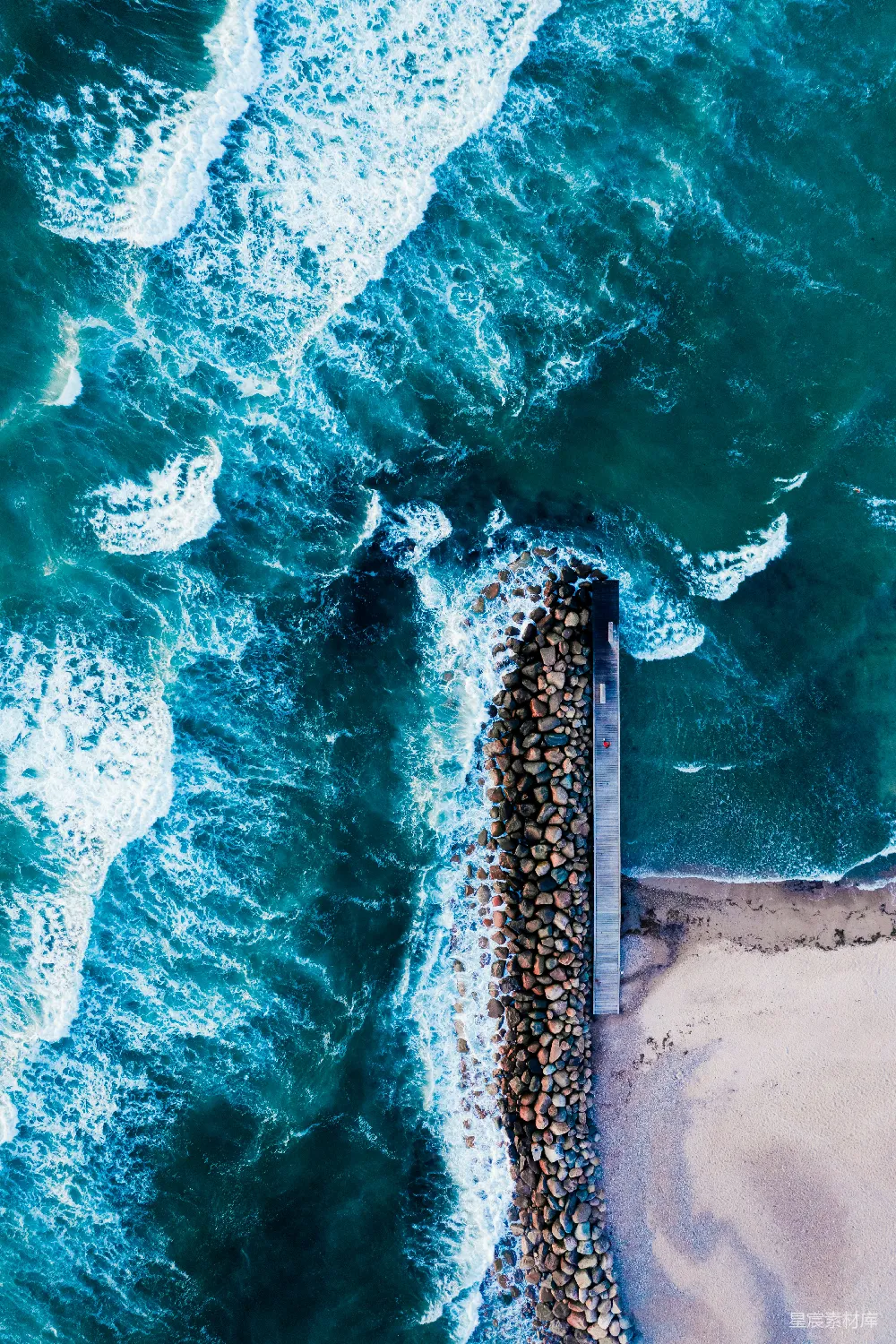白天海浪在岸边拍打的空中俯视景象