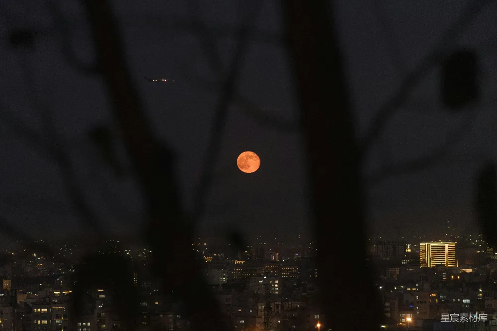 夜晚城市 skyline 上的血月。