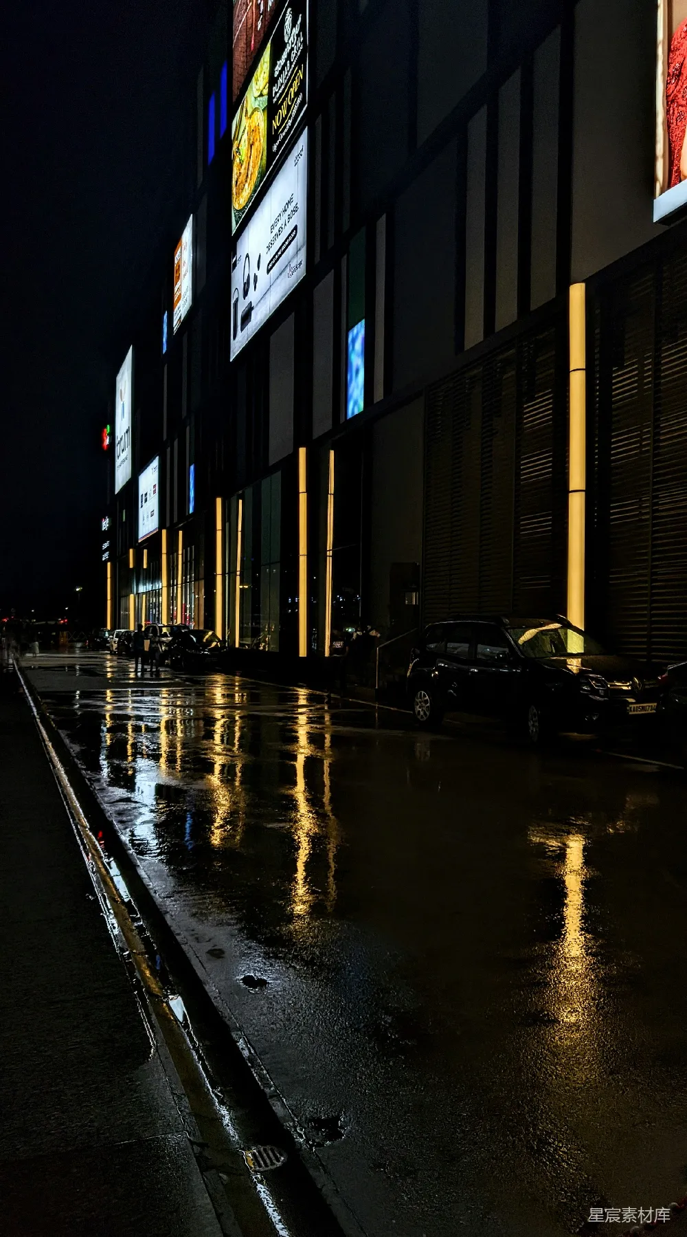 高清摄影  夜晚的城市街道，街道一侧停着汽车。