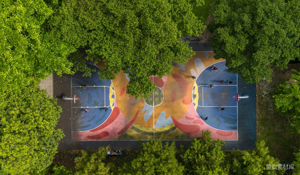 高清摄影  一副网球场地俯瞰图，周围环绕着树木。