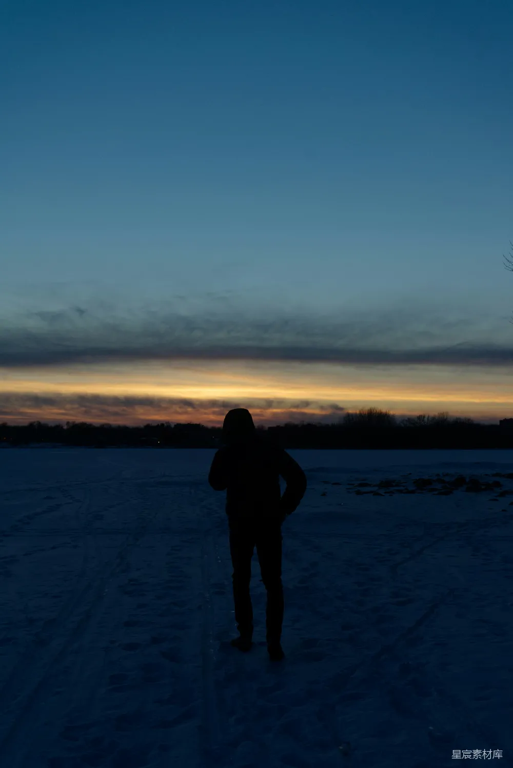 雪地里站着的人在夕阳下。