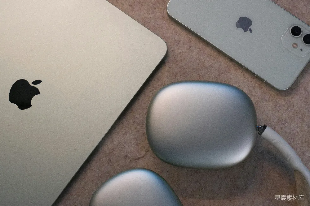 银色苹果 MacBook、iPhone 和 AirPods Max 耳机。